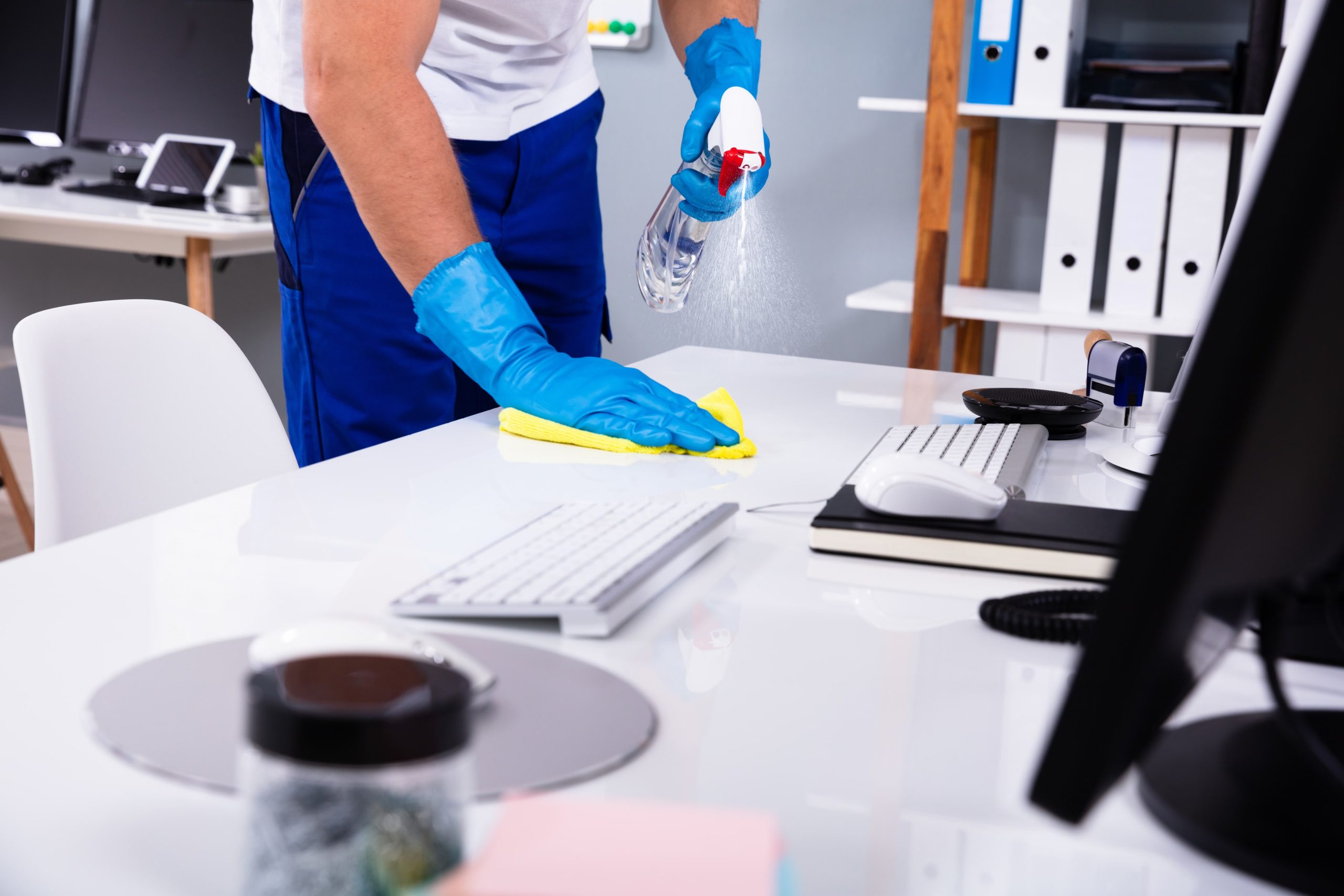 Worker in gloves cleaning desk