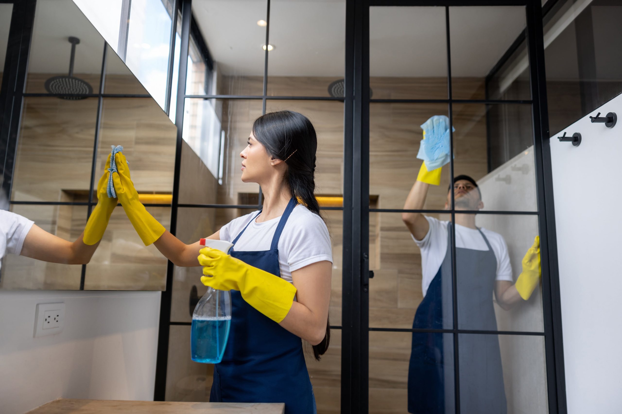 Two people cleaning glass surfaces
