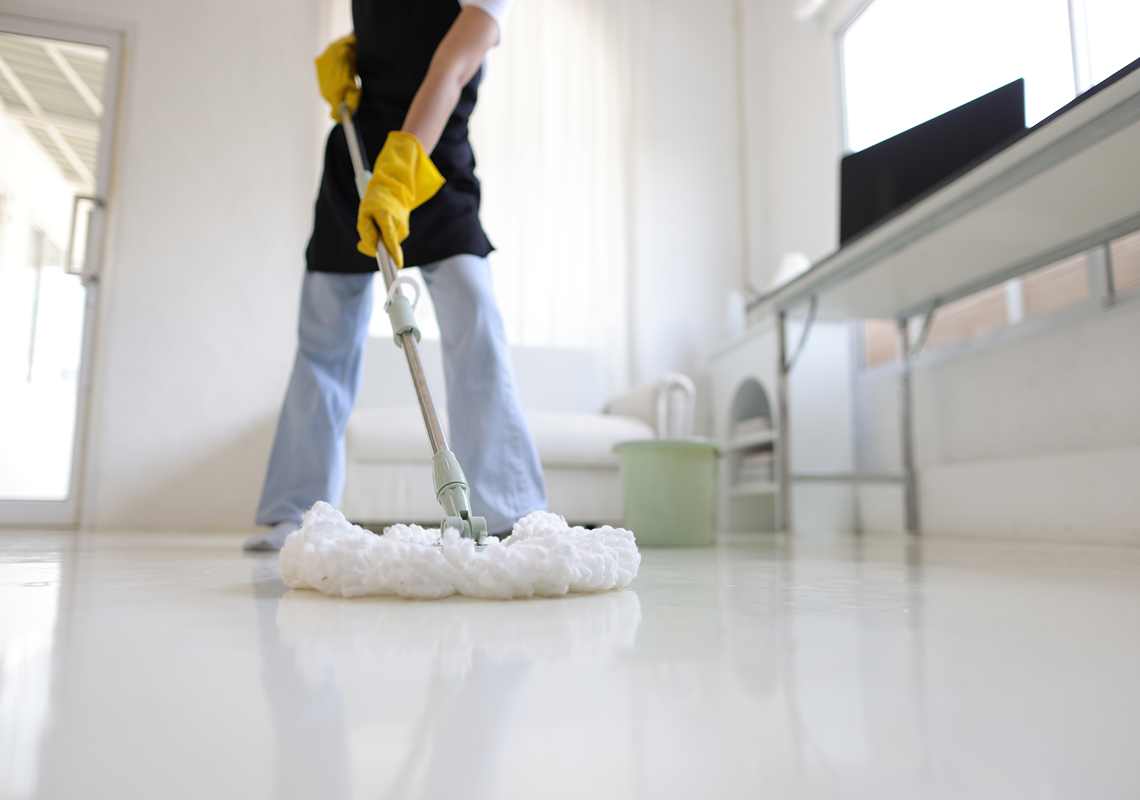 Person mopping polished white floor